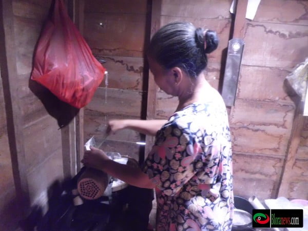 Ibu Rukmini sang pemilik warung sedang meracik kopi santan