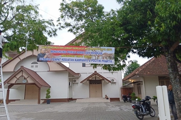 Spanduk bertuliskan dukungan untuk Pemilu Damai 2019 terpasang di Gereja St Willibrordus Cepu