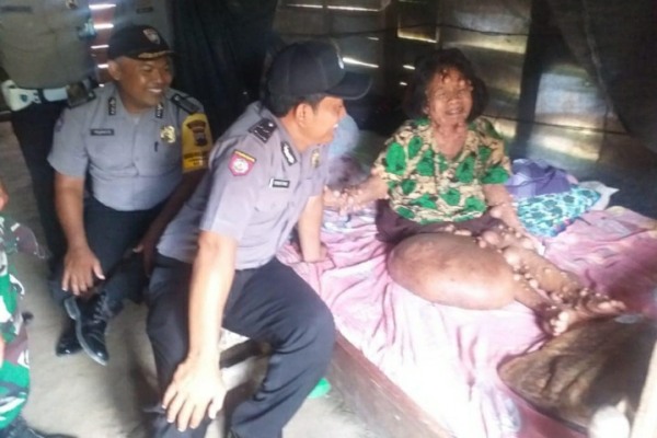 Petugas Polsek Jati Polres Blora menyerahkan bantuan kepada Lasiyem