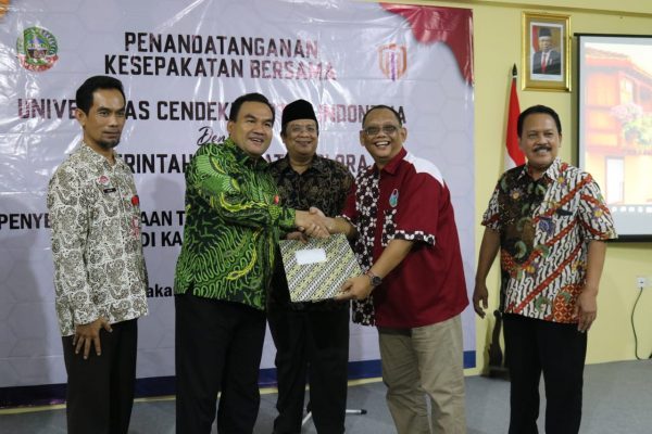 Berjabat tangan, penyerahan berkas penandatanganan MoU kerja sama antara UCMI dan Pemkab Blora.