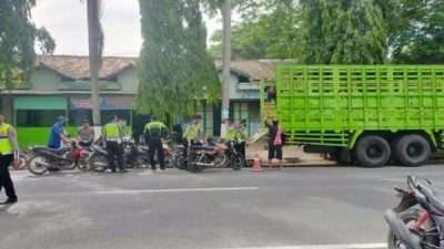 Polantas menaikkan motor hasil operasi ke dalam truk.