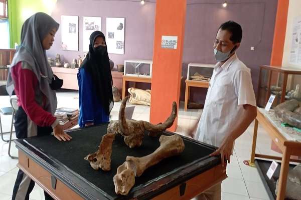 Petugas pengelola Rumah Artefak, Lukman Wijayanto menerangkan salah satu koleksi kepada pengunjung.
